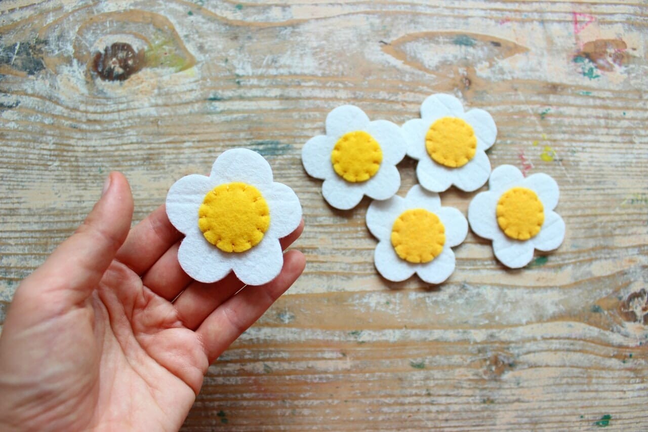 person holding yellow and white cupcakes
