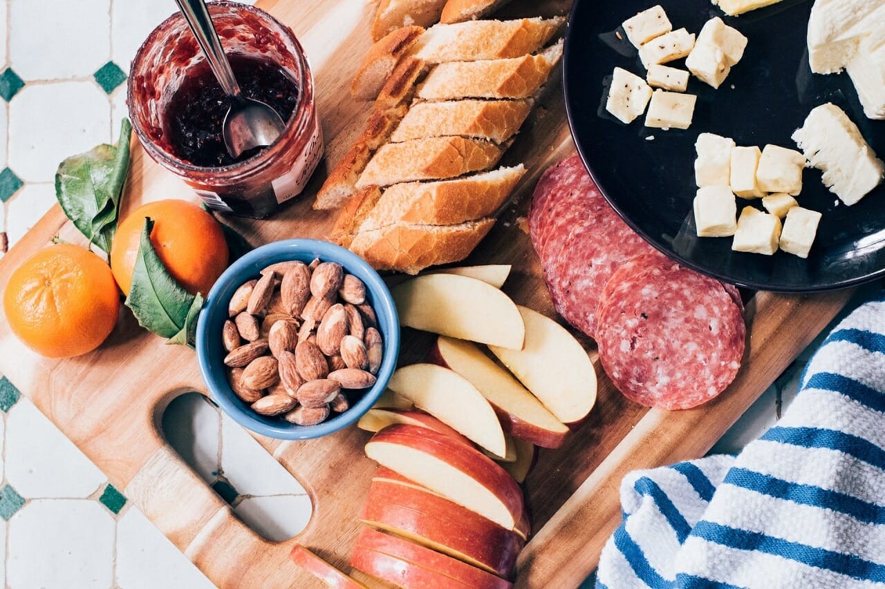 slice of apple and sausage on top of chopping board