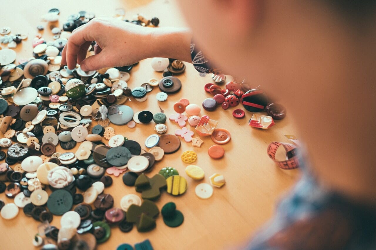 men sorting buttons on table