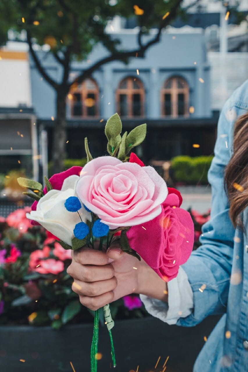 women holding petaled faux flowers