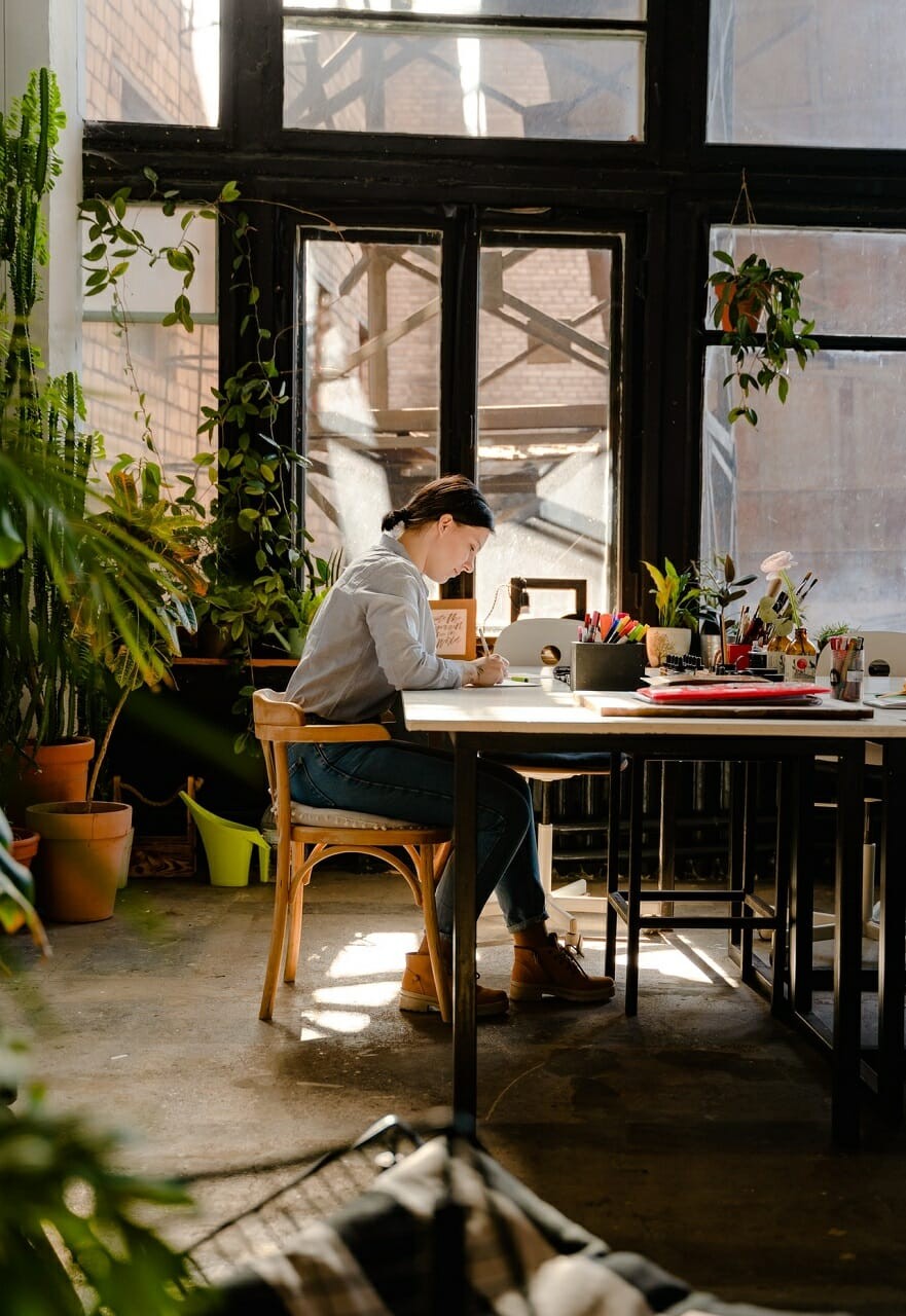 women sitting by the table and writing