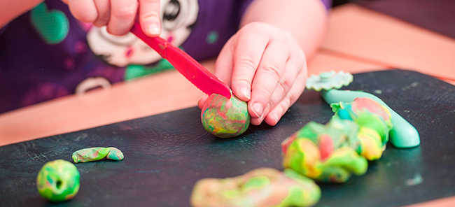 kid playing with play doh